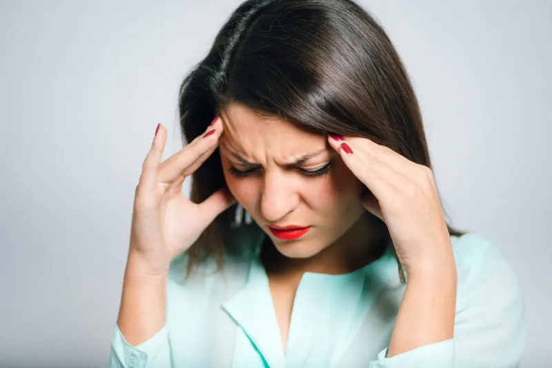 Woman pressing her temples with a headache